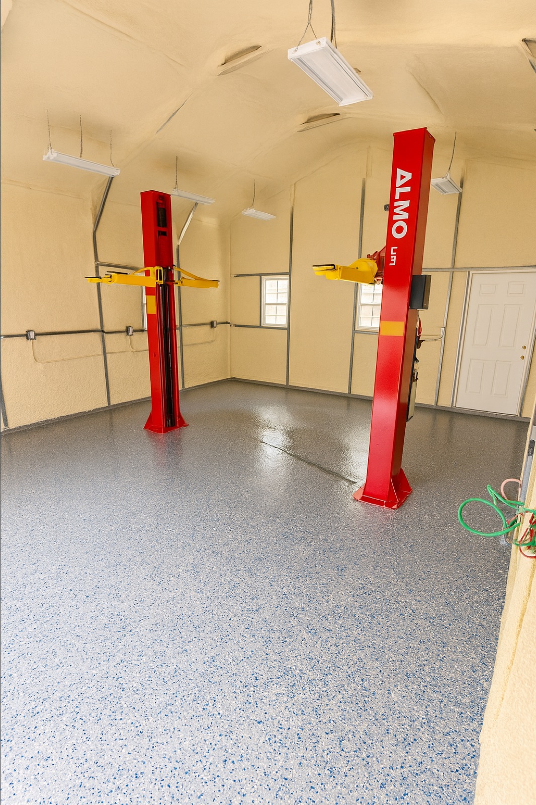 Auto shop with two car lifts on a flake epoxy floor